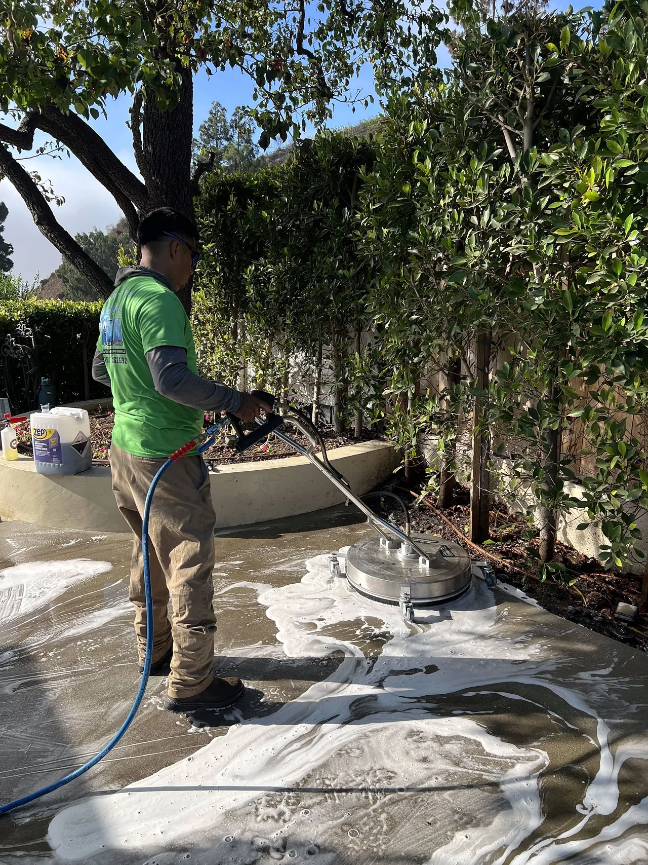 Zafra crew member pressure washing a backyard patio
