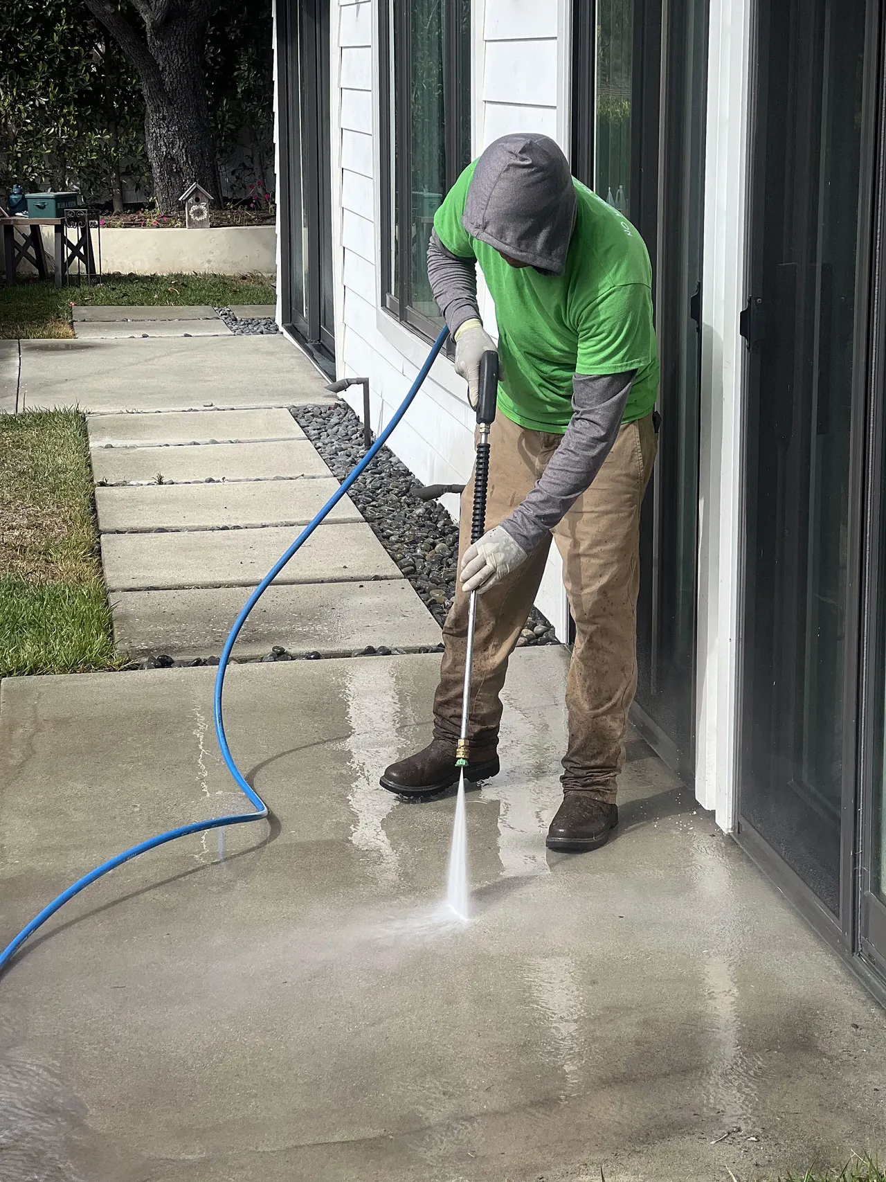 Zafra crew member pressure washing a concrete walkway