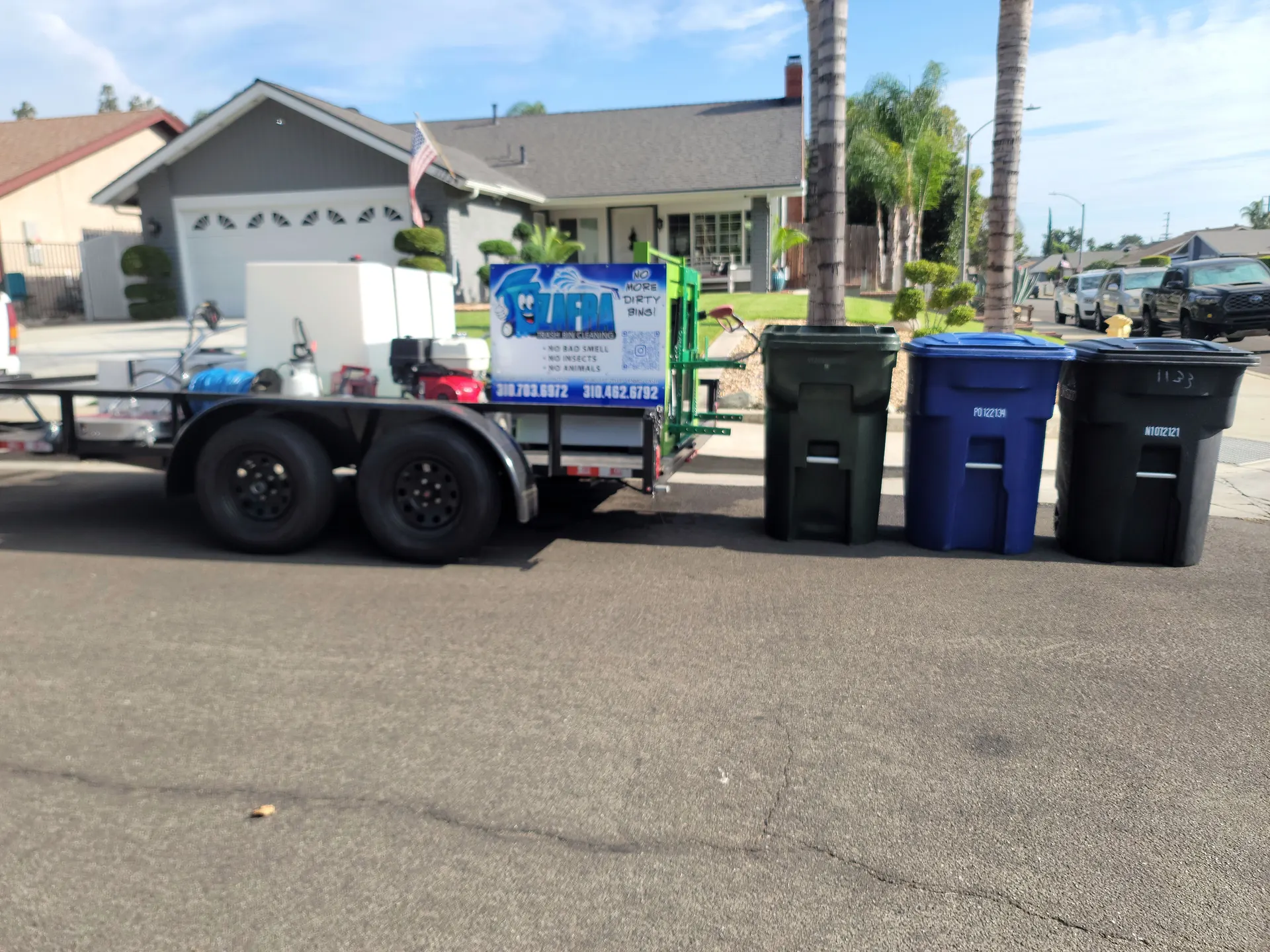 Zafra's cleaning trailer at the curb with freshly cleaned bins